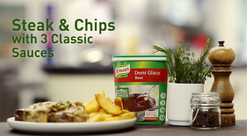 Steak and chips with a demi glace sauce on the side